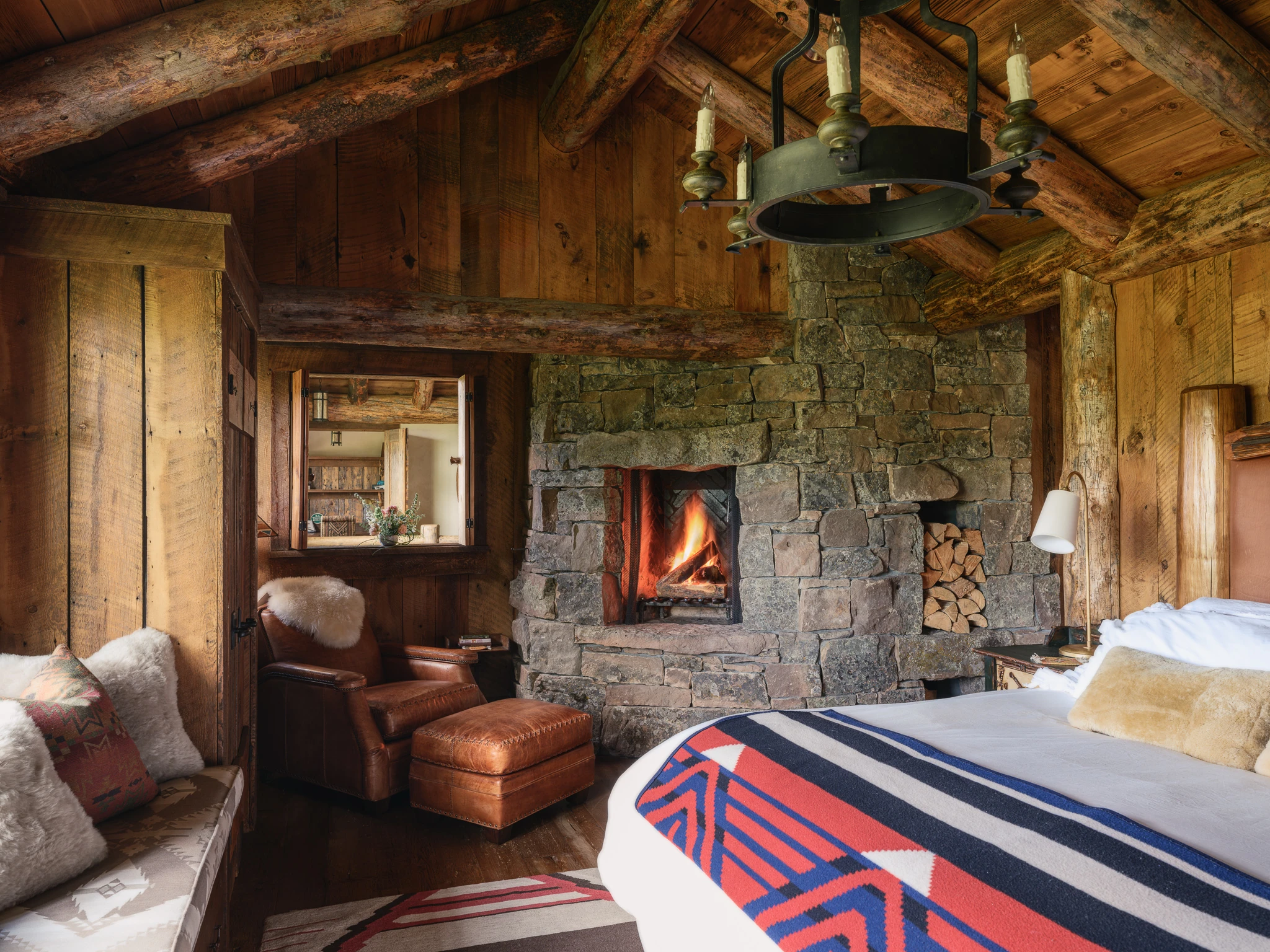 Primary bedroom stone fireplace detail — interior design photography Big Sky Montana, Lohss Construction